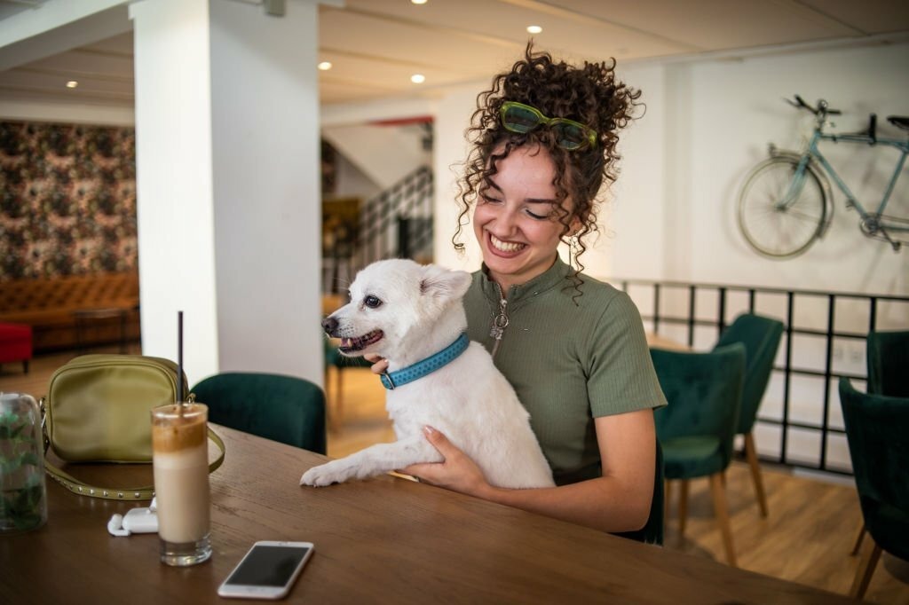 Woman with her dog in a restaurants 